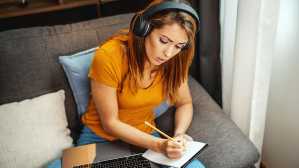 Mulher estudando em plataformas de curso de inglês online com fones de ouvido e notebook